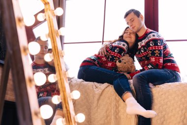 Erkek ve kız gözlerini kapatıp pencere eşiğinde oturuyorlar.