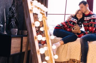 Erkek ve kız gözlerini kapatıp pencere eşiğinde oturuyorlar.