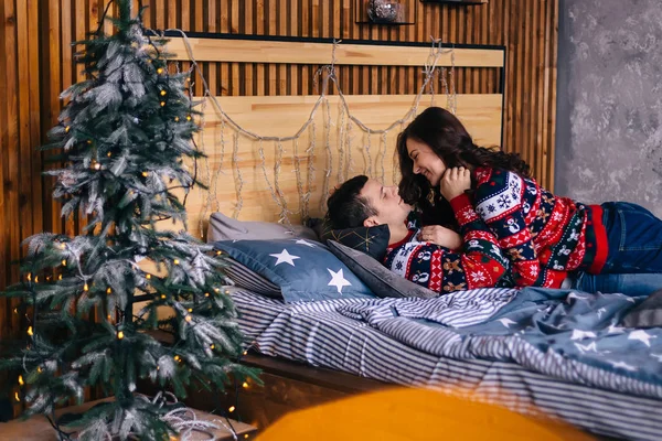 사랑하는 커플 이 침대에서 서로 쳐다보고 웃고 있습니다. 크리스마스 — 스톡 사진