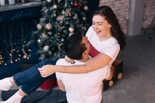 Vista dall'alto di un ragazzo che tiene una ragazza nella stanza vicino al camino e — Foto Stock