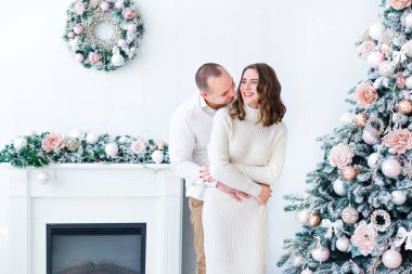 Adam kızı arkadan sarıp sarmalıyor. Ateş püskürten beyaz oda.