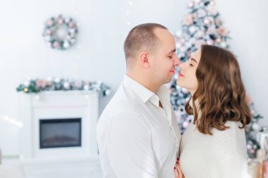 Erkek ve kız gözlerini kapatıp arka planda sarılıyorlar. 