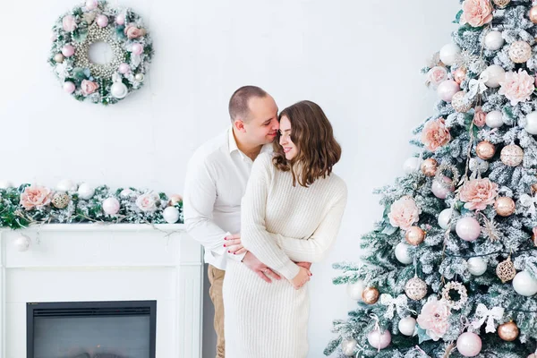 El tipo abraza a la chica de atrás. habitación blanca con chimenea — Foto de Stock