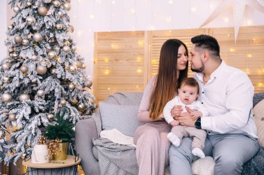 Ebeveynler kanepede oturur, öpüşür ve aralarında küçük bir çocuk olur..