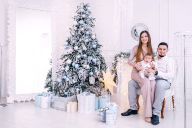 Aile, büyük bir ayna ve Noel 'in yanında bir koltukta oturur.