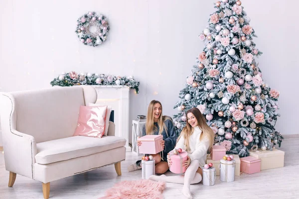 Giovani donne sorridenti che aprono una scatola regalo vicino al bellissimo Natale — Foto Stock
