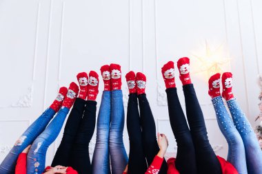 Kız bacakları beyaz bir duvarda yükseliyor. kot pantolon ve kırmızı s