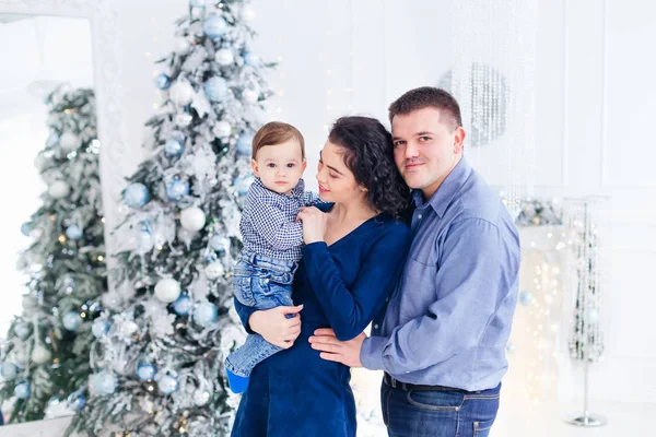 Famiglia con bambino in studio. vicino a un albero di Natale e — Foto Stock