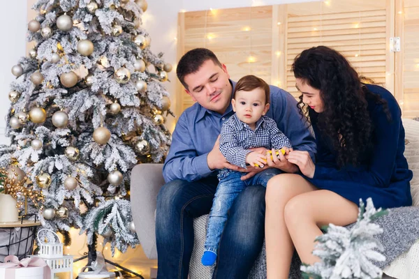 Bébé avec parents à Noël. Famille assise sur canapé près de Chri — Photo