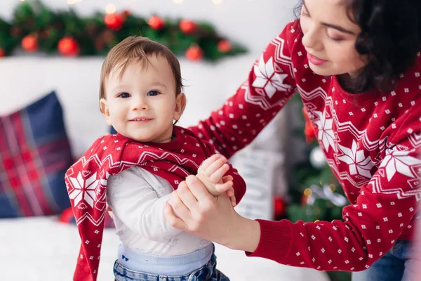 母親は息子に服を着せる。小さな男の子がカメラを見て — ストック写真