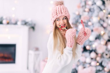 Örgü elbiseli genç bir kadın Noel tatlısı yiyor. Noel 