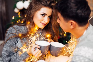 Adam ve kız bardak tutuyorlar ve birbirlerine bakıyorlar. Çift olun!