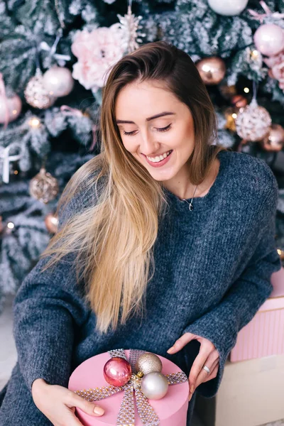 かわいい女の子座っているクリスマスツリーと保持ボックス — ストック写真