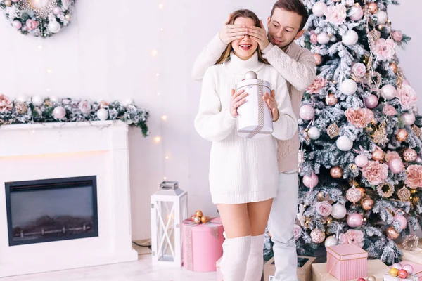 La chica sostiene el regalo y el chico hace una sorpresa para ella. ¿Qué? — Foto de Stock