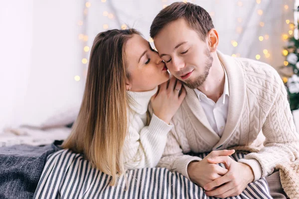 Couple en chandails tricotés blancs se trouvent sur le lit et embrasser. Nom de Dieu — Photo