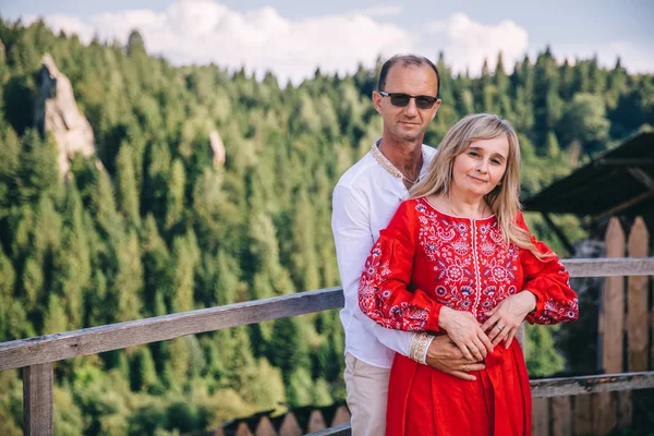 Die Eltern des Bräutigams liegen sich in den Armen und schauen in die Kamera. — Stockfoto