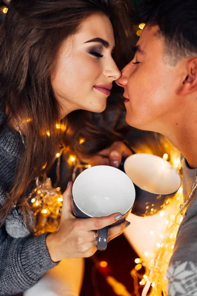 pretty girl in gray sweater and guy in gray sweater holding cups