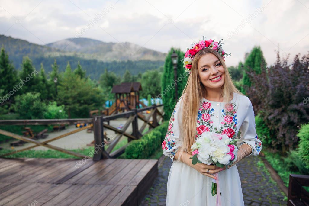 beautiful bride in an embroidered dress holds a wedding bouquet 