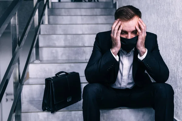 business man wear face mask and search his next job - he is being fired because of economic crisis due to coronavirus spread