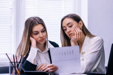 Masasında dosyaları olan iki üzgün ve yorgun iş adamı.