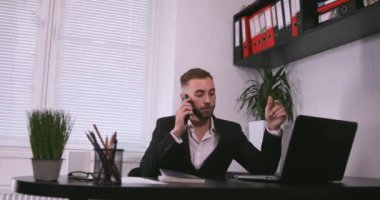 İş adamı akıllı telefondan konuşuyor ve ofiste çalışıyor. iş, insanlar, iletişim ve teknoloji kavramı