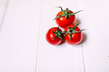 Kiraz domatesleri. Beyaz arka planda izole edilmiş üç kiraz domatesi.