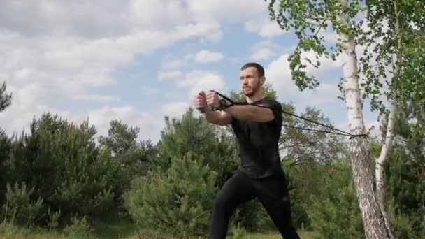 Musclé Homme Trains Avec Élastiques Bandes Plein Air Dans Parc — Video