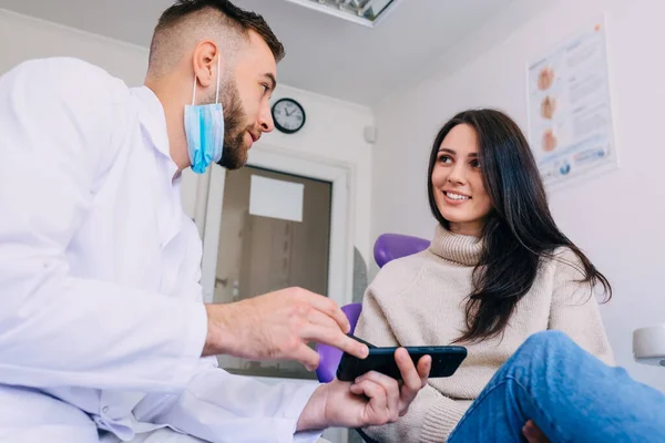 Dokter Toont Patiënt Een Röntgenfoto Van Telefoon Een Glimlachende Patiënt — Stockfoto