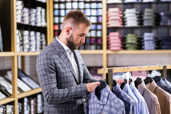 Young Man Stylish Plaid Suit Standing Hangers Boutique Choosing Shirts — Stock Photo, Image