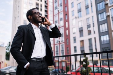Yakışıklı iş adamı, akıllı telefon kullanarak iyi haberler alıyor, diğer tarafa bakıyor.