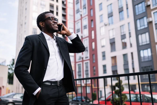 Yakışıklı iş adamı, akıllı telefon kullanarak iyi haberler alıyor, diğer tarafa bakıyor.