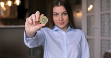 Altın Bitcoin gösteren genç bir kadın