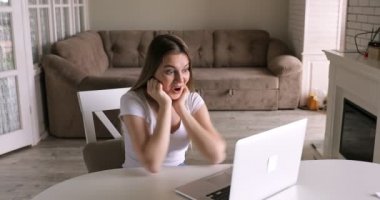 Coşkulu kız öğrenci online başarısını kutluyor harika haberler okuyor dizüstü bilgisayarını kullanıyor şaşkın şaşkın oturuyor, heyecanlı bir kadın bilgisayara bakıyor şaşırmış, sınav sonucu bursu almış.