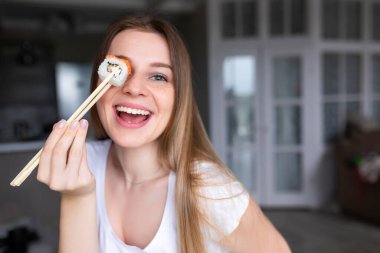 Yemek çubuğu tutan ve öğle yemeğinde oryantal yemek yiyen kadın müşteri..