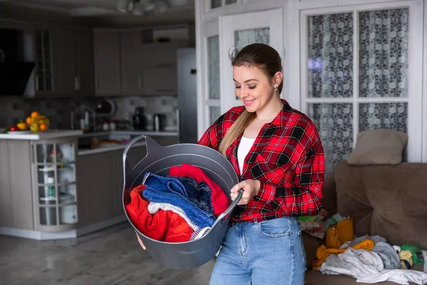 Счастливая Женщина Клетчатой Рубашке Держит Полную Корзину Белья — стоковое фото
