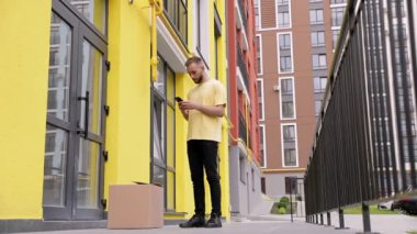 Bir teslimatçı / çocuk ürünleri sokağa getiriyor ve kapıların yakınına bırakıyor..