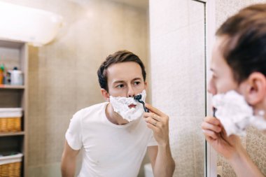 Genç yakışıklı adam sabah erkenden tıraş oluyor.