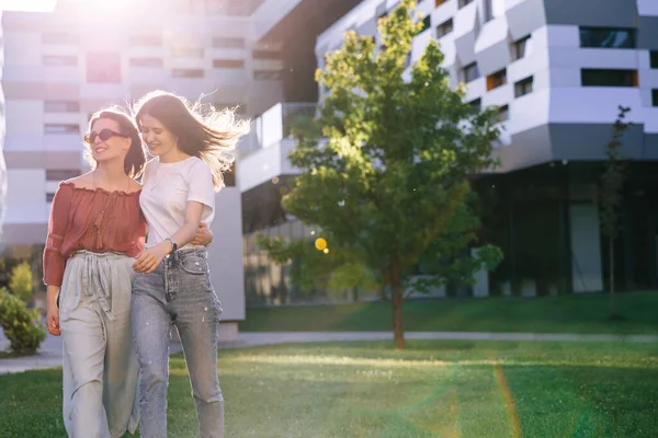 Sıradan kıyafetler giymiş genç yetenekli bayan öğrenciler parkta dolaşıyorlar. Öğrenciler dışarıda vakit geçirmeyi seviyorlar