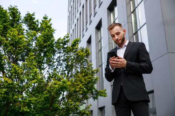 Takım Elbiseli Genç Adam Akıllı Telefon Kullanıyor — Stok fotoğraf