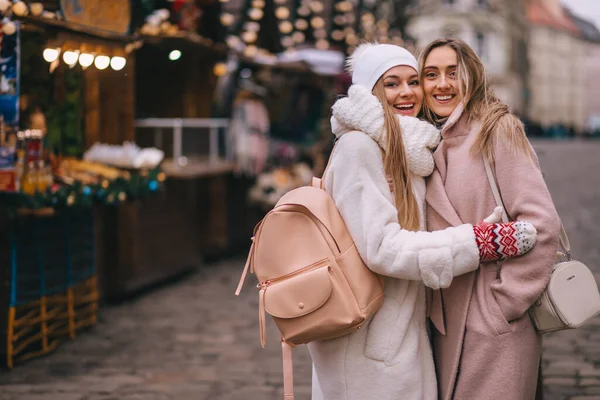 Noel Çelenkleriyle Süslenmiş Iki Kız Noel Pazarında Duruyor — Stok fotoğraf