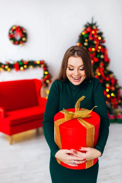 幸せな興奮若い女性保持ギフトボックス上のクリスマスツリー — ストック写真