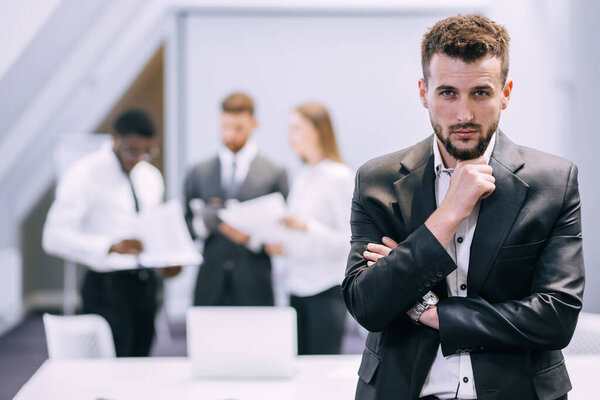 young businessman standing in modern office showing confidence and motivation at work, happy millennial european male CEO posing at workplace, leadership, success concept.