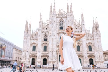 Milan İtalya 'nın Duomo' sunun önünde bir kadın modelin portresi. Beyaz elbiseli, uzun saçlı kız..