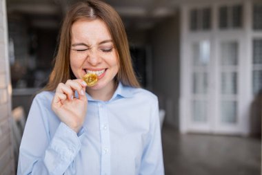 Bozuk para ısırmaya çalışan genç bir kız.