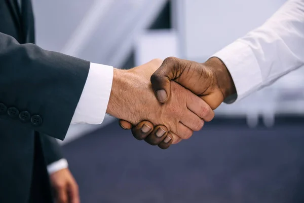 Business people in formal wear shaking hands, close up shot