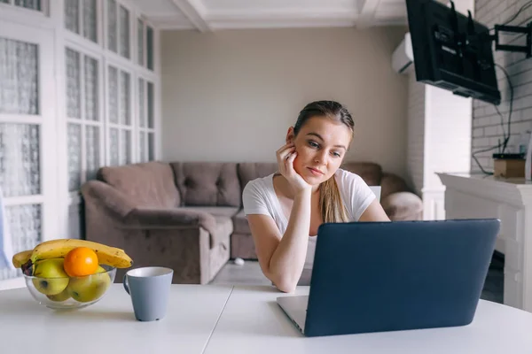 Triste Jovem Mulher Olha Para Laptop Casa Cozinha — Fotografia de Stock