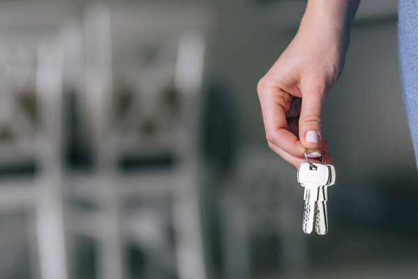 Closeup image of real estate agent holding keys from new home