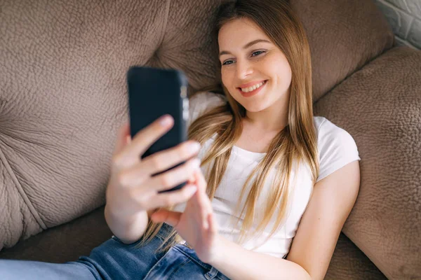 Menina Adolescente Sorridente Relaxante Enquanto Senta Sofá Casa Usando Vídeo — Fotografia de Stock