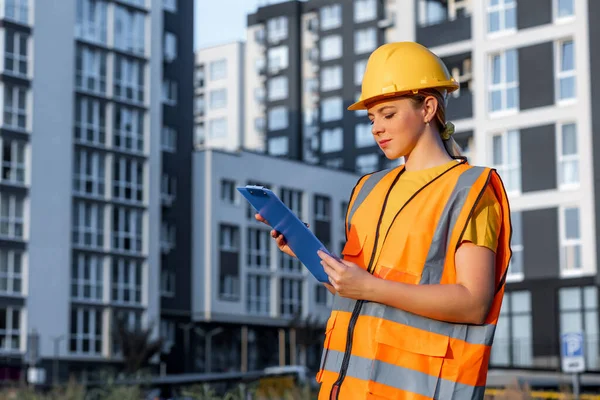 Construction professional analyzing blueprints at a modern residential building site