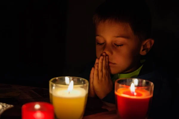 Niño Reza Delante Las Velas Expresión Concentrada Imagen De Stock